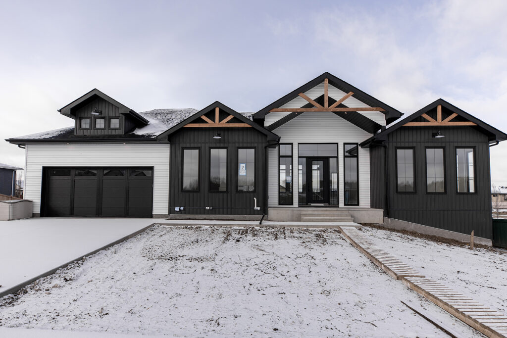 Large modern black and white residential home illustrating the impact of well-maintained siding on curb appeal and protection.