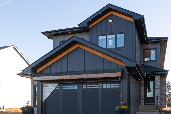 Modern residential home with dark grey siding and natural wood exterior accents, highlighting contemporary design.