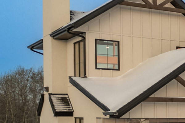 Close-up of cream-colored home exterior featuring professionally installed gutters and eavestrough system.