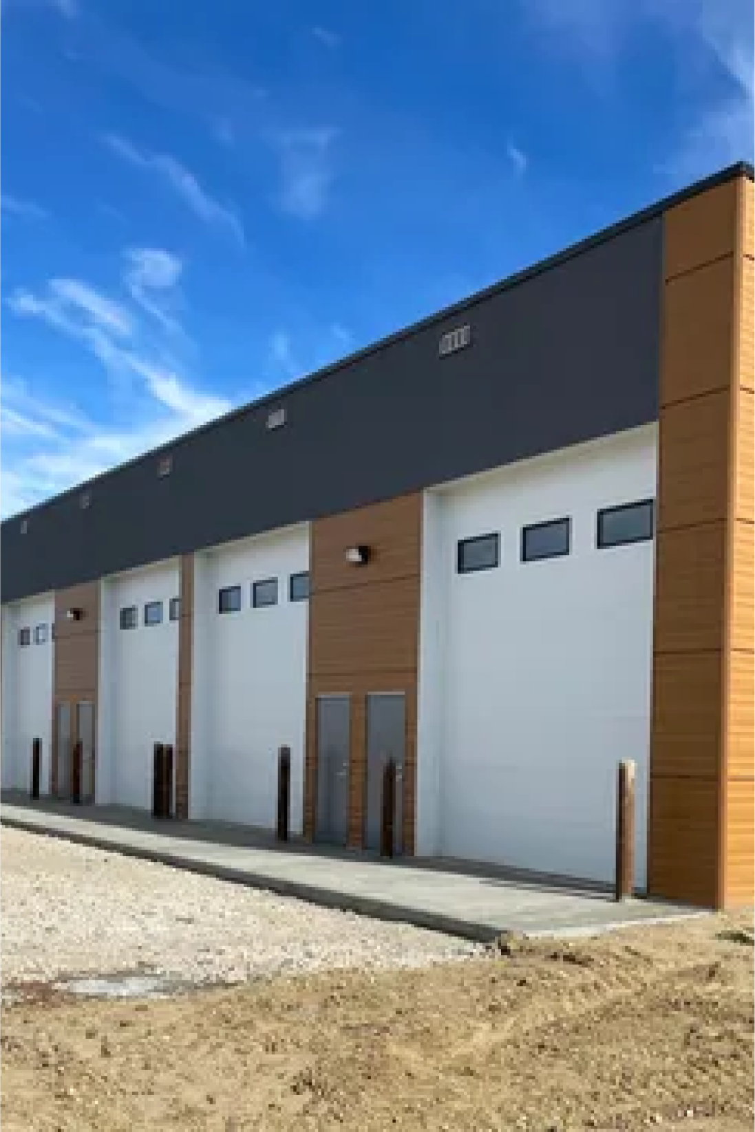 Commercial property with four white covered vehicle bays, designed for functionality and durable exterior performance.