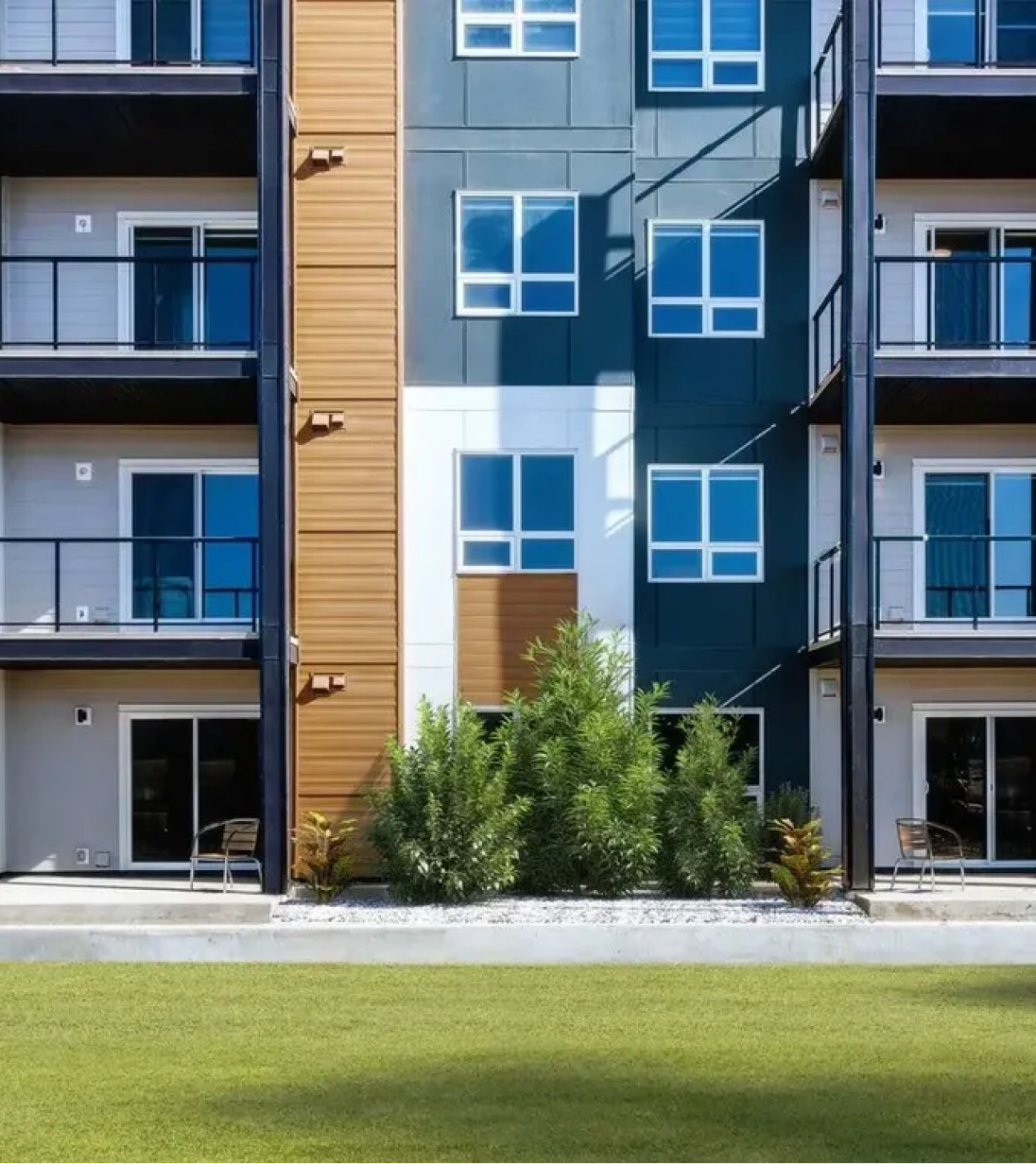 Modern multi-family building with black siding and wood accents, showcasing exterior design styles offered by Calgary’s Great Albertan Exteriors.